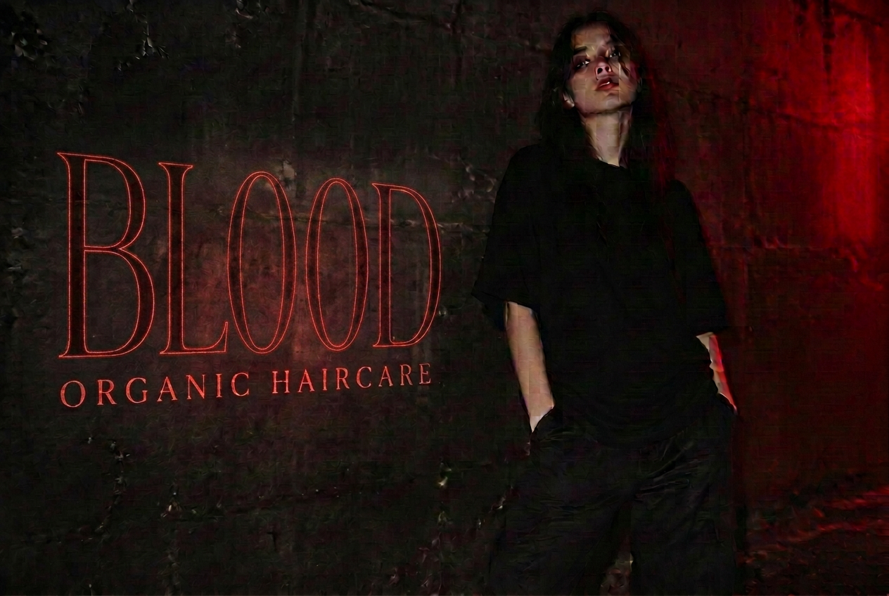 ΛMΛNDΛ campaign — oversized black silhouette against a red-lit concrete wall
